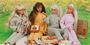 A photo of Barbie dolls having a picnic.