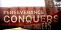 a sign that says Perseverance Conquers