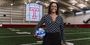 Associate Professor Debra Blair holding a ball on a Temple field