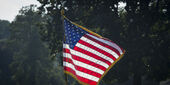 The American flag outside near trees