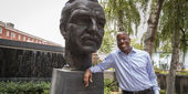 President Jason Wingard stands beside a bust of Temple University founder Russel Conwell.