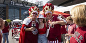People wearing cherry and white shirts at a Temple University homecoming event.