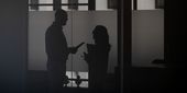 Two profiled silhouettes of two staff members talking with each other.