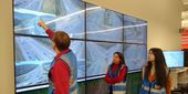 Researchers review data on a screen.
