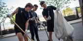 Image of men's soccer players cleaning up the area near Temple Sports Complex.