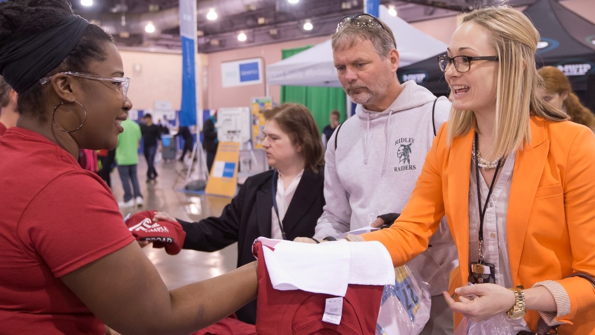 Members of the university hand out t-shirts at the convention center in philadelphia