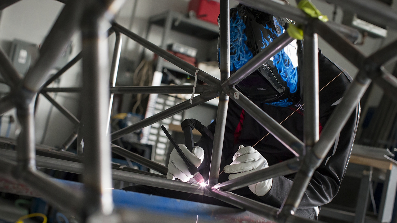 A student welding together the frame of the car. 