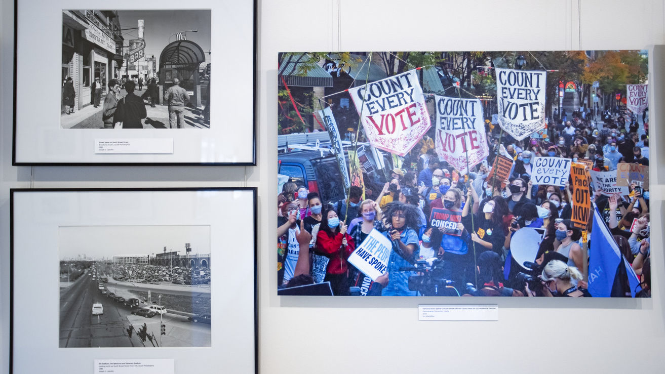 Pictured on the left are images of downtown Philadelphia on South Broad Street near Snyder Avenue, and of JFK Stadium, the Spectrum and Veterans Stadium in the 1980s taken by Joseph V. Labolito. On the right, Jim MacMillan photographed demonstrators gathering outside around the Pennsylvania Convention Center while officials counted votes for the U.S. presidential election in 2020. (Photography by Ryan S. Brandenberg)
