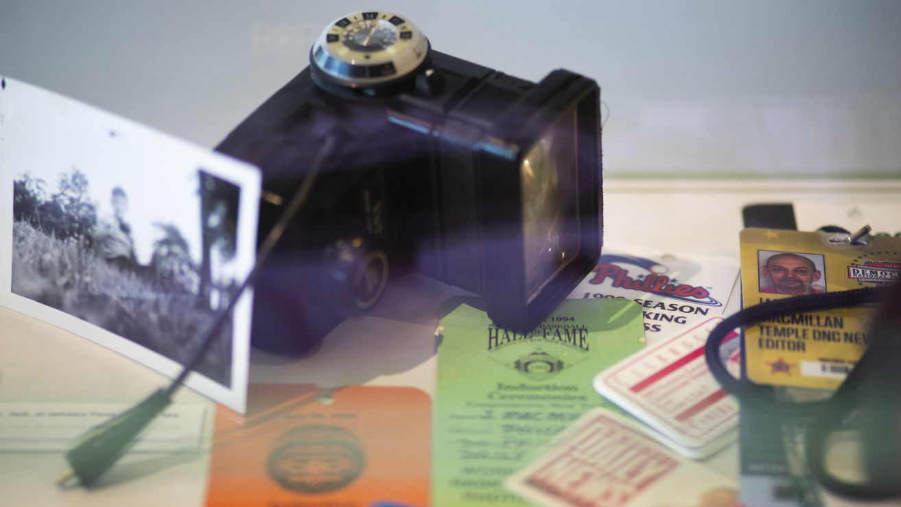 Additional accessories of this exhibit include a Vivitar 285 on-camera flash, a favorite of news photographers in the 1980s, according to Jim MacMillian. In addition, a black-and-white photo of MacMillan when he was 8 years old and credentials from his career. (Photography from Ryan S. Brandenberg)