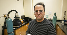 Image of Mehdi Khanzadeh holding a sample of carbonatable concrete.