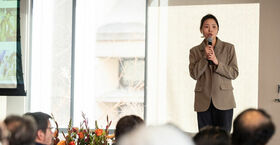 graduate student standing on stage with a mic