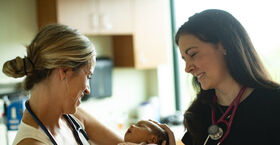 Female physicians with a baby