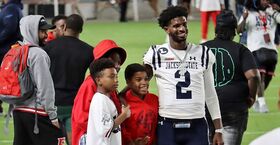Shedeur Sanders pictured with two young men.