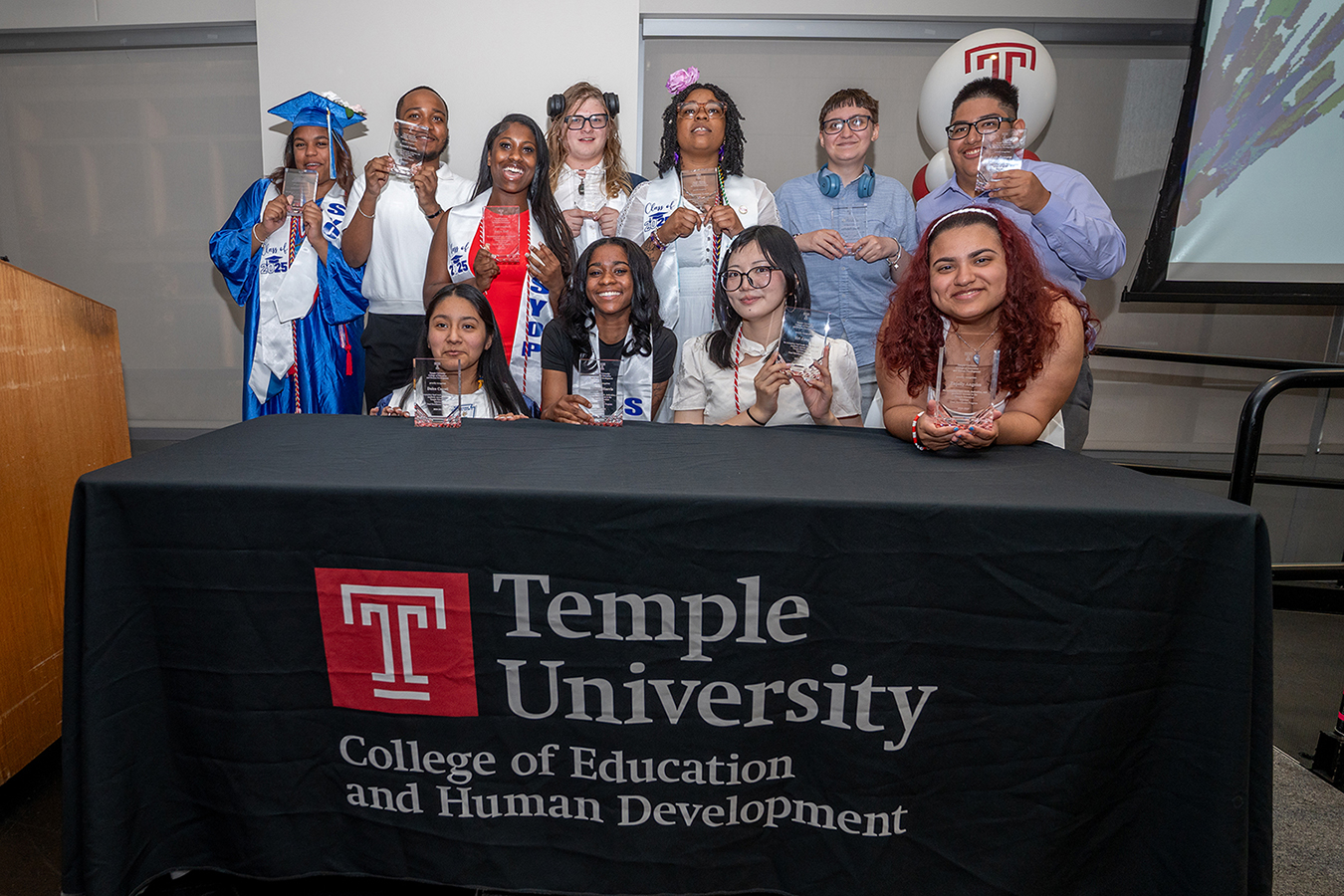 Program participants pose in a group shot behind a table