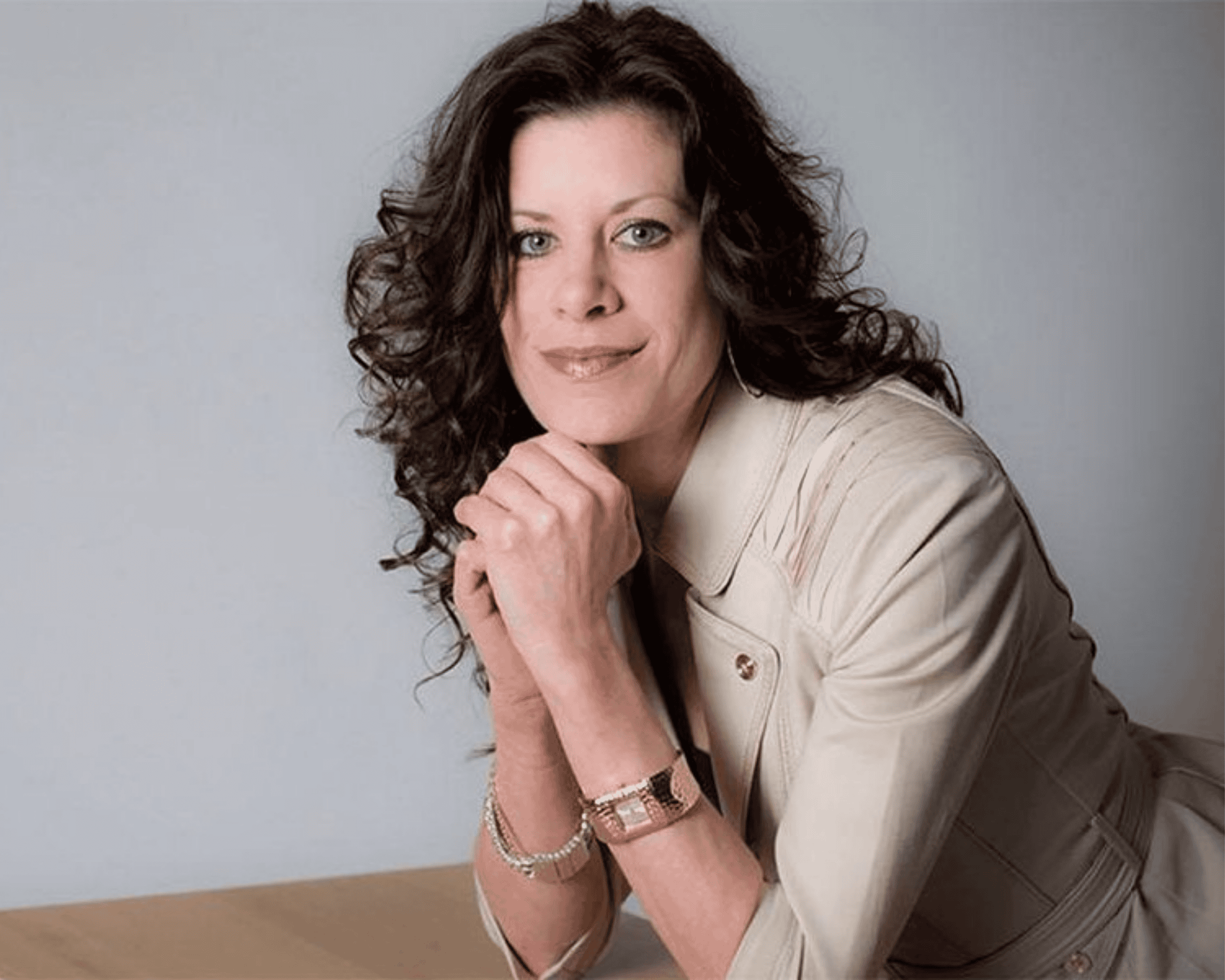 Woman in light jacket and long dark hair in a professional headshot